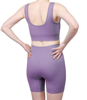 Gri kurdeleli atletik giysili bir kadının poposunun detaylı görüntüsü. Yüksek bel şort onun kıvrımlarını vurguluyor. Kumaşın tırtıklı dokusu açıkça görülüyor. Stüdyo ışıklandırması, beyaz arka plan. Spor kıyafetleri ve fitness reklamları için uygun. 