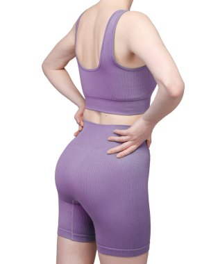 Gri kurdeleli atletik giysili bir kadının poposunun detaylı görüntüsü. Yüksek bel şort onun kıvrımlarını vurguluyor. Kumaşın tırtıklı dokusu açıkça görülüyor. Stüdyo ışıklandırması, beyaz arka plan. Spor kıyafetleri ve fitness reklamları için uygun. 