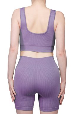 Gri kurdeleli atletik giysili bir kadının poposunun detaylı görüntüsü. Yüksek bel şort onun kıvrımlarını vurguluyor. Kumaşın tırtıklı dokusu açıkça görülüyor. Stüdyo ışıklandırması, beyaz arka plan. Spor kıyafetleri ve fitness reklamları için uygun. 