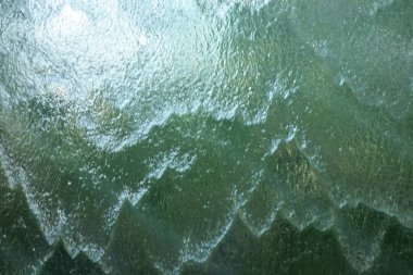 Camın sonsuz yüzeyinde akan su deseni.