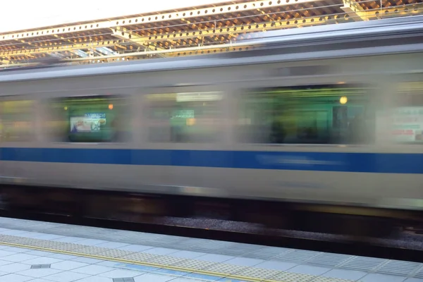 A passenger car train that runs through the platform of the station at a tremendous speed