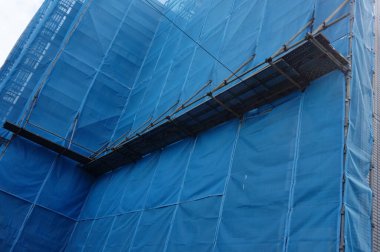 İnşaat sahalarında mavi çarşaflarla kaplanmış inşaat çalışmaları görülüyor.