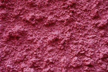 Yüzeyi pürüzlü, pembemsi duvar.