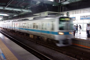 Tren istasyonu platformu, her araç çeşitli yolcular gösteriyor.