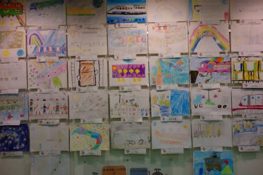 Çocukların çizdiği resimler duvarın her yerinde sergileniyor..