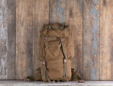 Sırt çantası ve aksesuarlar ahşap bir masada.