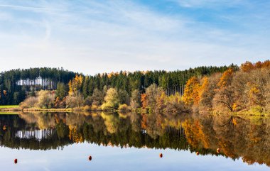 Sonbahar yaprakları Bavyera 'daki Windach rezervuarının suyuna yansıyor.
