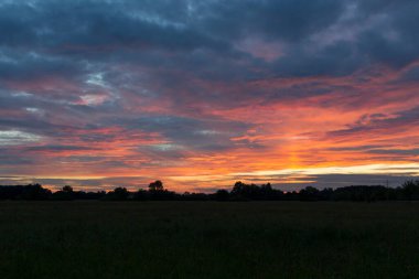 Augsburg yakınlarındaki Siebenbrunn 'daki meyve bahçelerinin üzerinde gün batımı