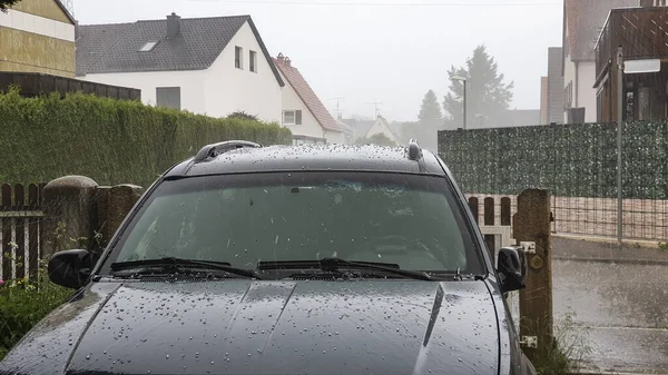 Hail falls on the roof and bonnet of a car