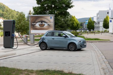 Oberkochen, Almanya Bavyera 08-16-2021: Fiat 500e Convertible Zeiss şirketinin forum binasının önündeki ENBW Quick-Charger 'ın pillerini şarj ediyor