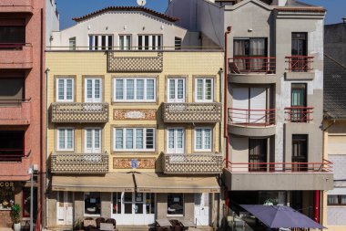 Balkon ve beyaz pencereli sarı azulejo binası cephesi, Portekiz, Ovar Furadouro, 9.10.2025.