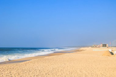 Wide sandy beach and ocean waves under clear blue sky, Portugal, Ovar, 8.10.2025