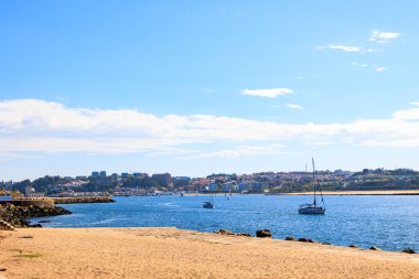 Uzak şehir manzaralı, Portekiz, Porto, 11 Ekim 2025 'te sakin mavi sularda yüzen yelkenliler.