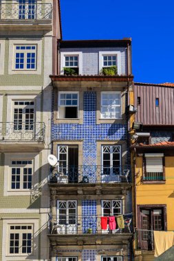 Ribeira, Portekiz, Porto 'da balkonlardan sarkan azulejo fayansları ve çamaşırları olan renkli geleneksel evler, 11 Ekim 2025