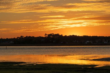 Günbatımında lagün kanalı olan kıyı sulak arazisi geniş görüşlü Furadouro Portekiz, Ovar Furadouro, 12 Kasım 2025.