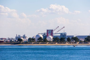 Büyük yakıt depolama tankları ve sanayi kıyı şeridi soluk gökyüzü, Portekiz, Aveiro, 13 Ekim 2025