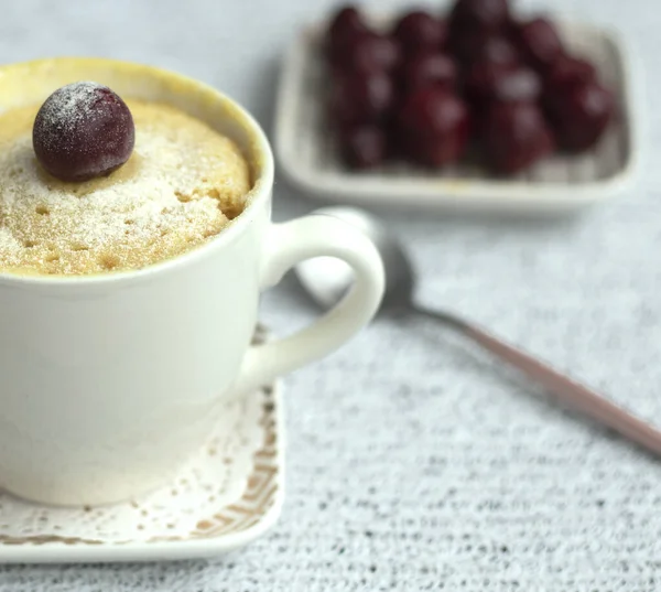 Vanilla cupcake with cherries in a mug. Delicious sweet dessert — Stock Photo, Image