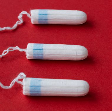 Pamuktan ve diğer malzemelerden oluşan hijyenik tampon, kırmızı üzerine yakın plan. 