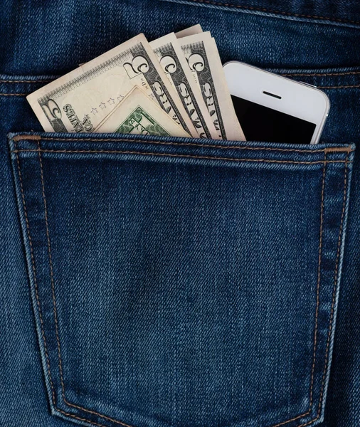 mobile phone and dollar bills in jeans pocket.