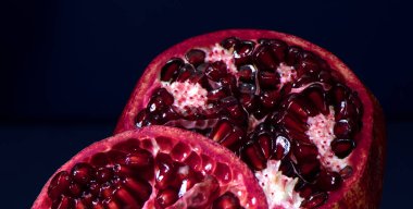 Siyah desenli arkaplanda nar. Nar parçaları ve tohumlar.