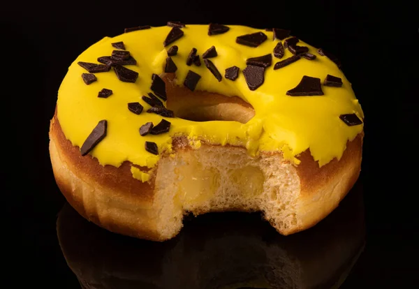 Sweet donut with icing and chocolate drops, isolated on background.