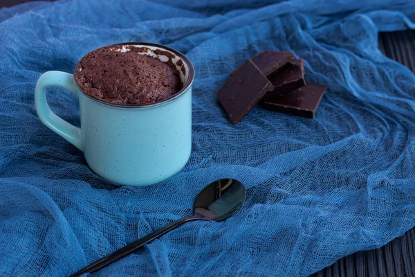 A chocolate cupcake in a mug is cooked in the microwave. — Stock Photo, Image