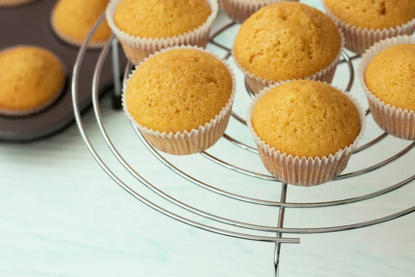 Čerstvě upečené vanilkové muffiny jsou chlazeny na spirálovém stojanu. Domácí pečení. — Stock fotografie