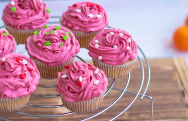 Kırmızı kremalı ve desenli kekler, inciler ve kırmızı ve yeşil yıldızlar.. 