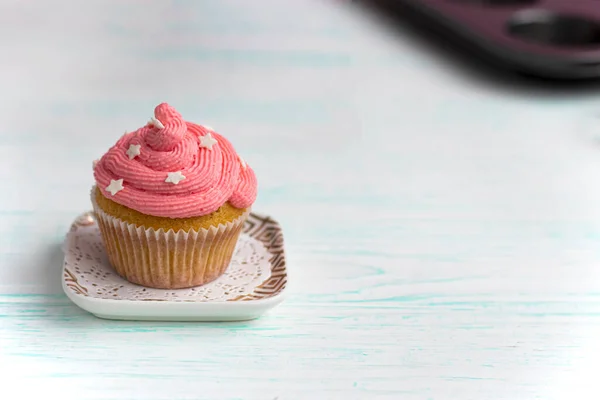 Muffin mit fliederfarbener Creme verziert mit essbaren Perlen — Stockfoto