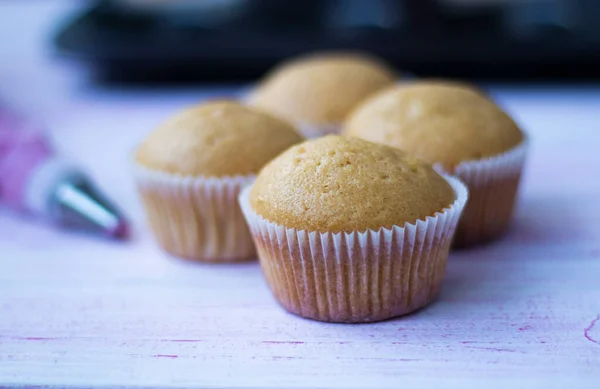 Čerstvě upečené dortíky chladí na mřížce. plísně s muffiny. — Stock fotografie