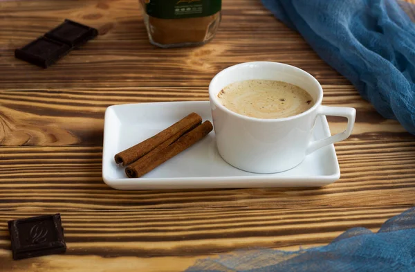 A cup with cappuccino stands on a saucer, on a wooden background. — Stock Photo, Image
