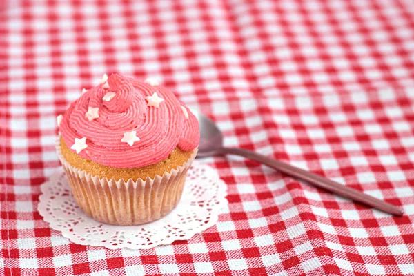 Muffin ist mit rosa Buttercreme und Zuckersternen dekoriert — Stockfoto