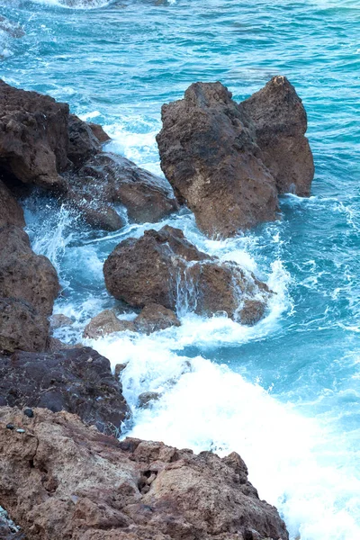 Onde che si schiantano contro la scogliera, primo piano. spruzzi d'acqua — Foto Stock