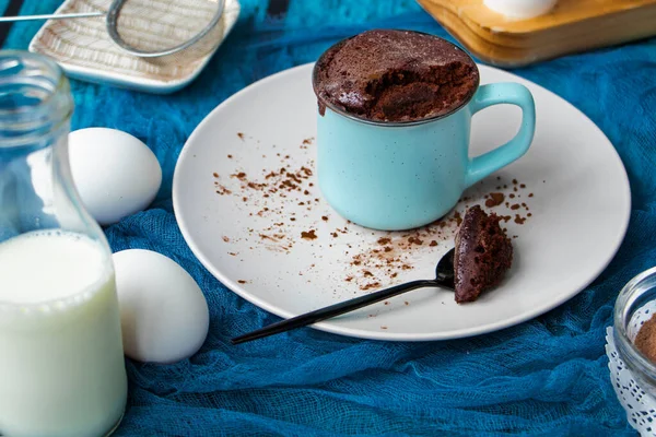 Mugcake is microwaved. Homemade cupcake in a mug is on a plate. — Stock Photo, Image