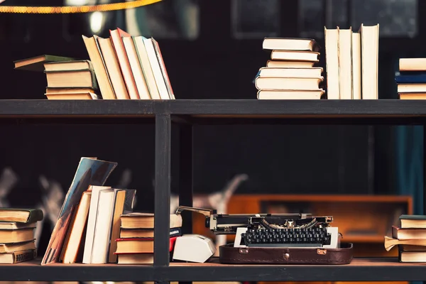 Bücher und Schreibmaschine im Holzregal — Stockfoto