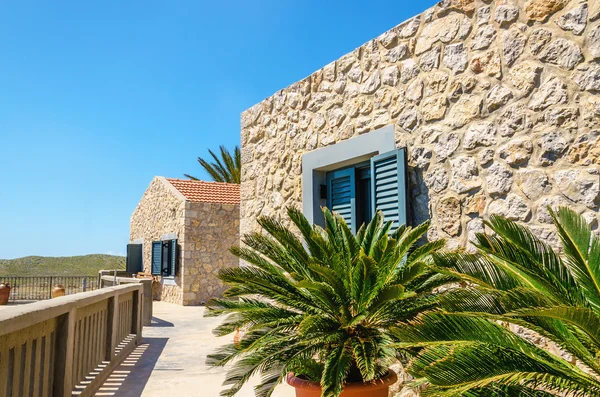 Typical wall of old Greek buildings and palm trees — Stock Photo, Image