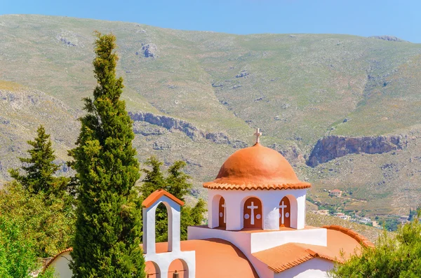 Greek church in mountains with cyprus garden — Stock Photo, Image