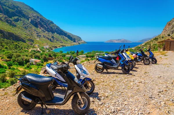 Skotter parkert og i sjømat med strand, Hellas – stockfoto