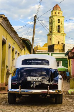 Car, colonial building and old church
