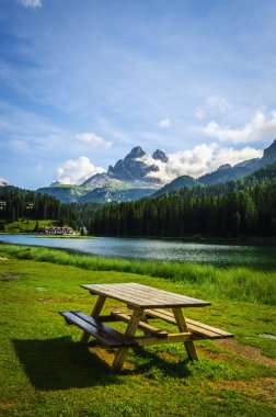 Wooden bench and table at the Misurina Lake clipart