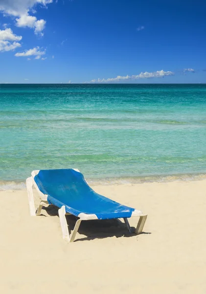 Blauwe zonnebank op zandstrand — Stockfoto