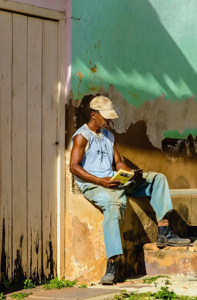 Cubano lendo um livro à sombra — Fotografia de Stock