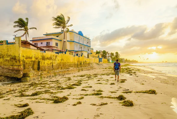 Homem com uma mochila andando ao longo da praia — Fotografia de Stock