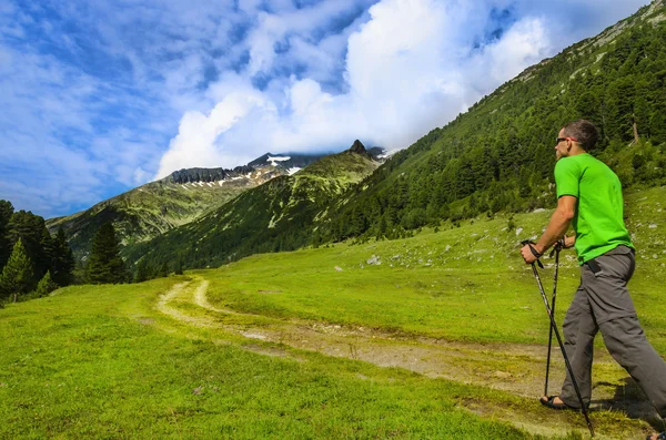 Bergsbestigaren med polackerna på alpine spår — Stockfoto