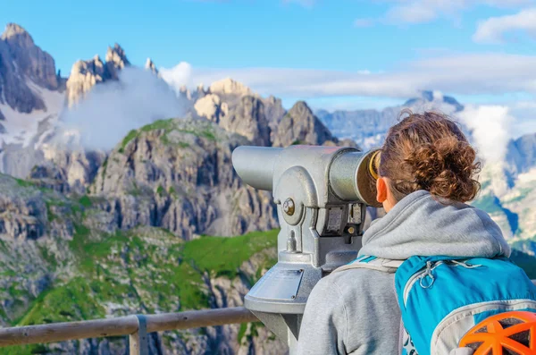Vrouw op zoek door middel van verrekijkers op de bergen — Stockfoto