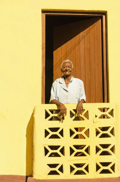 Velha mulher enrugada de pé em uma varanda — Fotografia de Stock