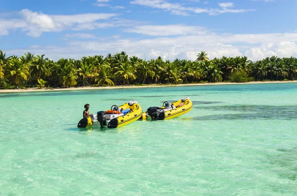 Jovem Caribe em pé na água com barcos — Fotografia de Stock