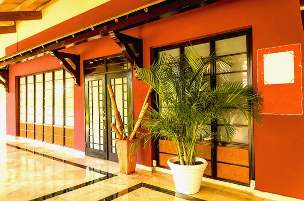 Porche del patio trasero con puerta de madera y pérgola adjunta. Vista