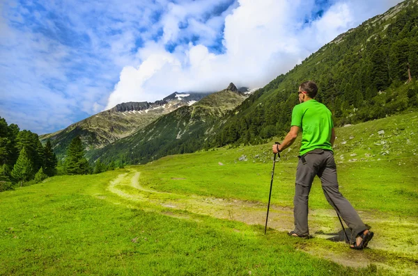 Bergsbestigaren med polackerna på alpine spår — Stockfoto