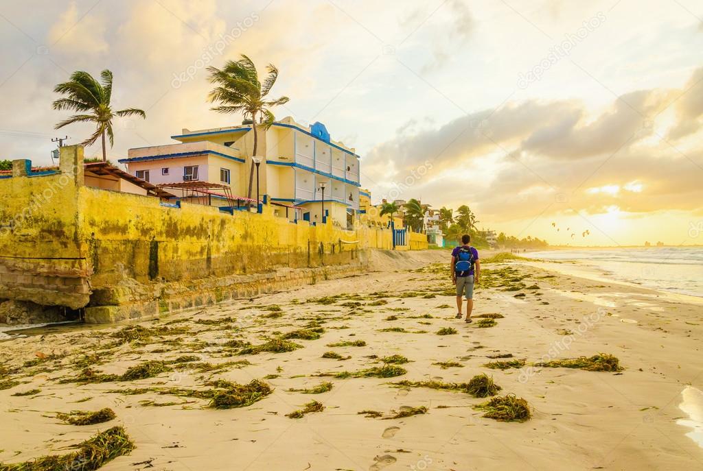 man with a backpack walking along the beach